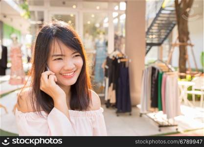 Beautiful young brunette woman calling by phone in the shop