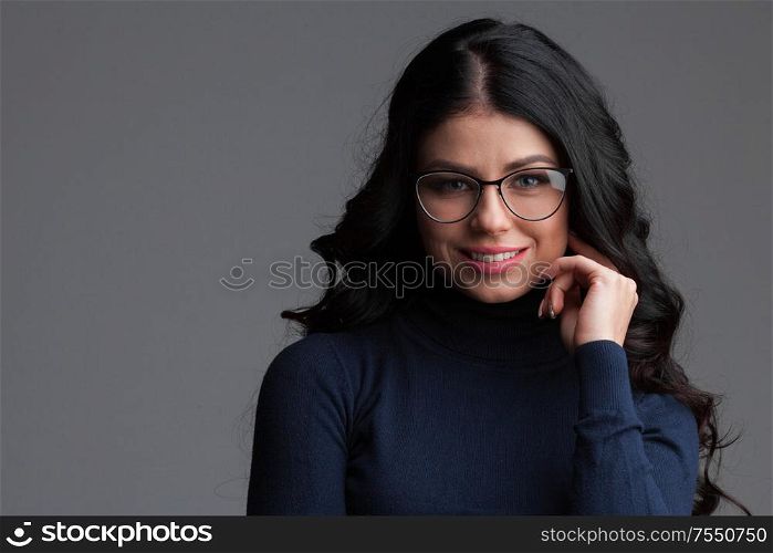 Beautiful young brunette woman in glasses , gray background, copy space for text. Beautiful woman in glasses