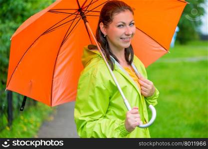 beautiful young brunette woman with an orange umbrella closeup