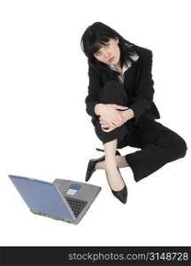 Beautiful young business woman sitting on floor with laptop. Full body over white.