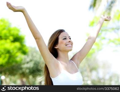 Beautiful young carefree women relaxing on the park with arms outstretched