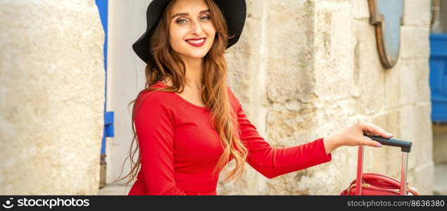 Beautiful young caucasian woman in black hat smiling and sitting on stairs at the door outdoors. Beautiful young caucasian woman in black hat smiling and sitting on stairs at the door outdoors.
