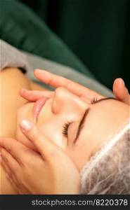 Beautiful young caucasian woman with closed eyes receiving a facial massage in a beauty salon. Beautiful young caucasian woman with closed eyes receiving a facial massage in a beauty salon.