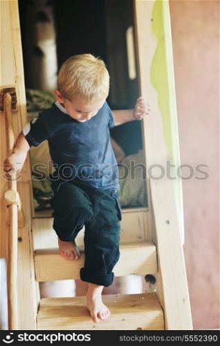 beautiful young child making first steps and have fun in play ground