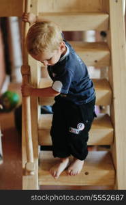 beautiful young child making first steps and have fun in play ground