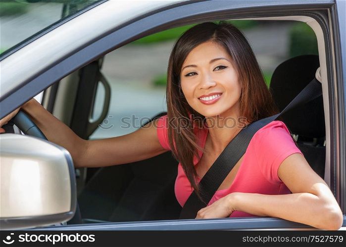 Beautiful young Chinese Asian American girl or young woman driving a car