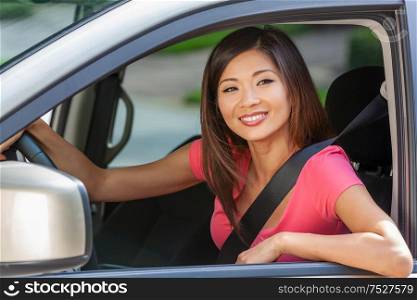 Beautiful young Chinese Asian American girl or young woman driving a car