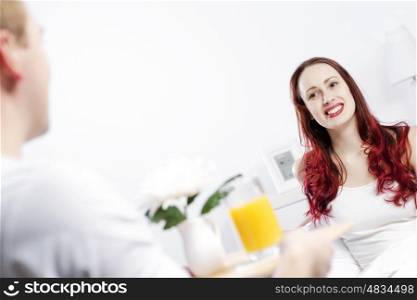 Beautiful young couple having breakfast in bed. Good morning darling
