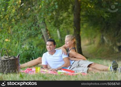 beautiful young couple having picnic in countryside
