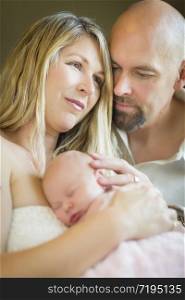 Beautiful Young Couple Holding Their Newborn Sleeping Baby Girl Inside.