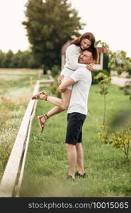 beautiful young couple hugging and having fun outdoors in the park on a warm summer sunny day.. beautiful young couple hugging and having fun outdoors in the park on a warm summer sunny day