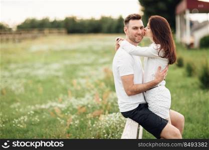 beautiful young couple hugging and having fun outdoors in the park on a warm summer sunny day.. beautiful young couple hugging and having fun outdoors in the park on a warm summer sunny day
