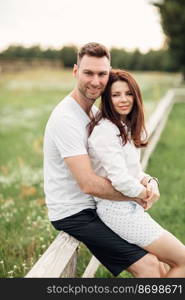 beautiful young couple hugging and having fun outdoors in the park on a warm summer sunny day.. beautiful young couple hugging and having fun outdoors in the park on a warm summer sunny day