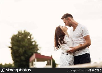 beautiful young couple hugging and kissing outdoors in the park on a warm summer sunny day. Love story.. beautiful young couple hugging and kissing outdoors in the park on a warm summer sunny day. Love story