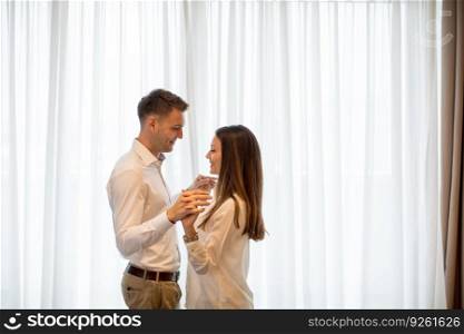 Beautiful young couple in love at home standing by  the window and embracing