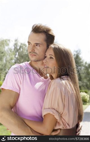 Beautiful young couple looking away in park
