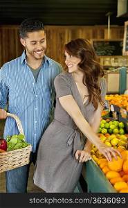 Beautiful young couple shopping together in market