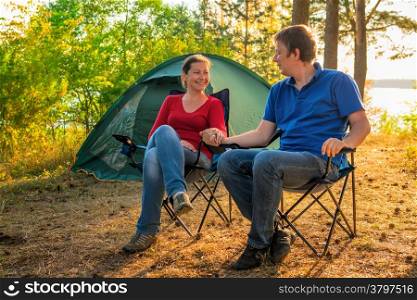 beautiful young couple sitting next to the tent
