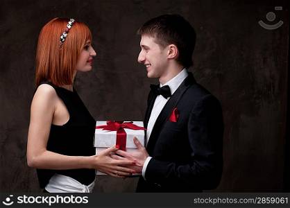 Beautiful young couple with a gift box.