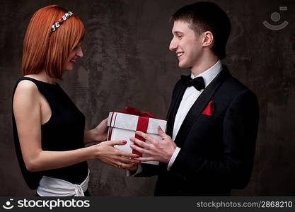 Beautiful young couple with a gift box.