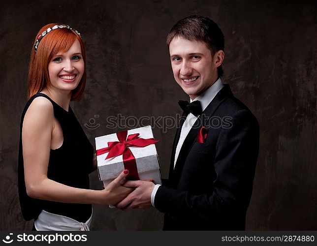 Beautiful young couple with a gift box.