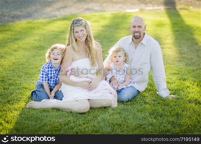 Beautiful Young Family Portrait Outside on the Grass.