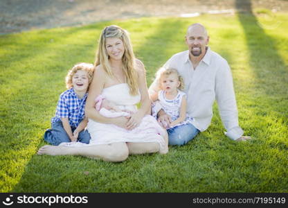 Beautiful Young Family Portrait Outside on the Grass.