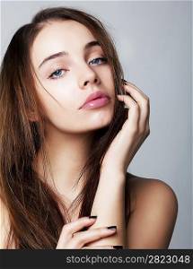 Beautiful young female face with a wellness complexion - isolated on grey