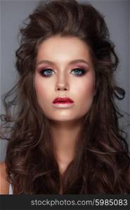 Beautiful young female face with bright fashion multicolored make-up.