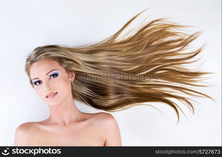 beautiful young female face with long blond straight hair as background