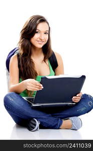 Beautiful young female student sitting on floor studying on a laptop, isolated on white