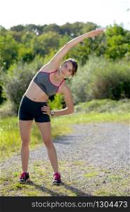 beautiful young fitness woman doing exercise in countryside