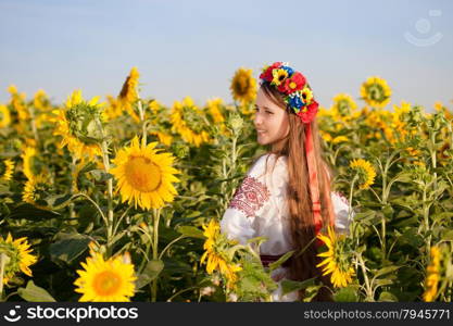 Beautiful young girl at sunflower field. Ukrainian girl