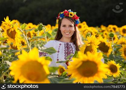 Beautiful young girl at sunflower field. Ukrainian girl