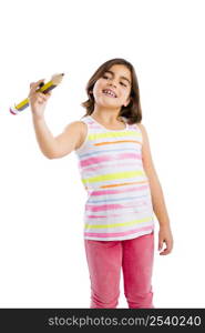 Beautiful young girl holding a big pencil and writing something on a glass wall