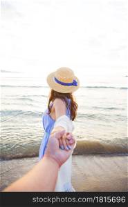 beautiful young girl holding a guy by the hand and looking at the sea.. beautiful young girl holding a guy by the hand and looking at the sea