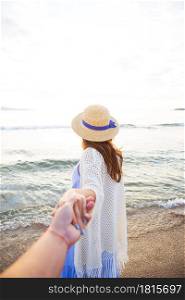 beautiful young girl holding a guy by the hand and looking at the sea.. beautiful young girl holding a guy by the hand and looking at the sea