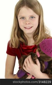 Beautiful young girl holding doll. Shot in studio over white.