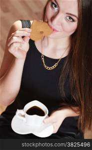 Beautiful young girl holding heart shaped cup of coffee drinking eating cookie, unusual high angle view