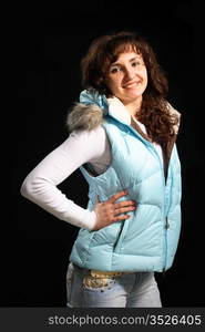 Beautiful young girl in a white woman&rsquo;s jacket and jeans on the black background