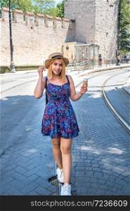 Beautiful young girl in fashionable clothes with ice cream walks road of Tramway vehicle in Istanbul,Turkey.Traveler woman lifestyle Concept.. Beautiful girl discovers Istanbul city in Turkey
