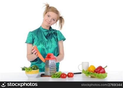 beautiful young girl in the kitchen rubbing carrots. Isolated on white background