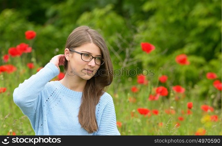 Beautiful young girl in the poppy field