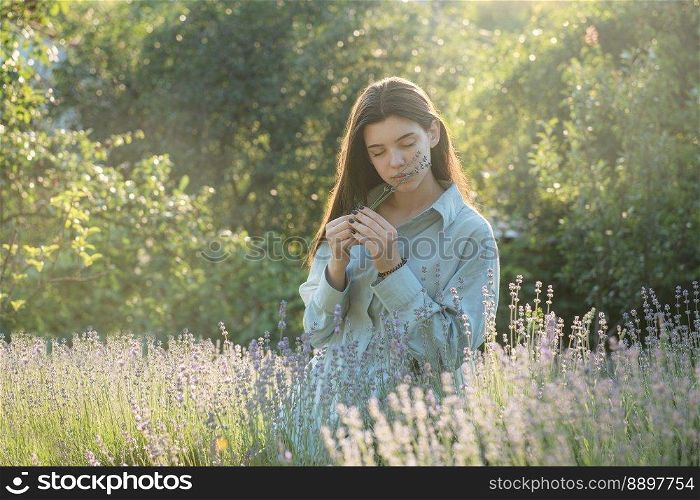 Beautiful young girl on lavender field. Sunset. Attractive young female outdoors.