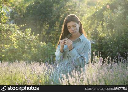 Beautiful young girl on lavender field. Sunset. Attractive young female outdoors.