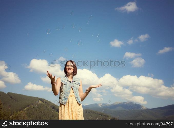 Beautiful young girl playing with soap bubbles