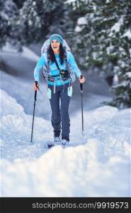 Beautiful young girl practicing ski touring in the woods