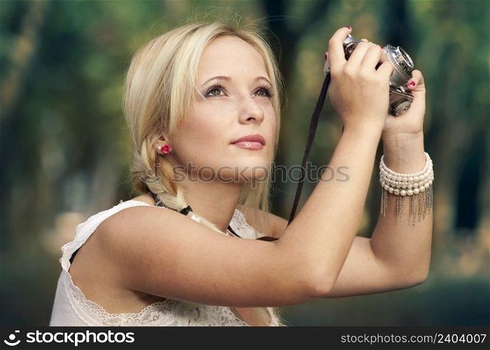 Beautiful young girl taking pictures with a old vintage camera