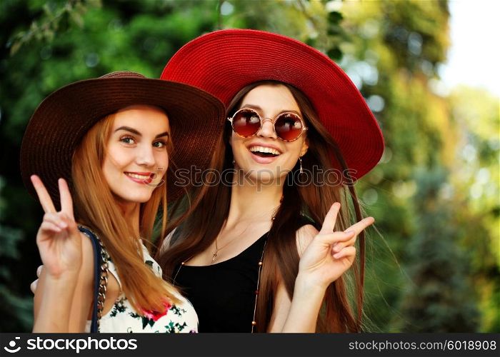 Beautiful young hippie girls outdoors enjoying nature. Trendy boho fashion