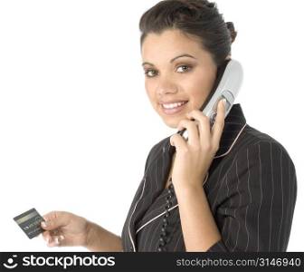 Beautiful young Hispanic business woman with credit card and telephone. Looking at camera.